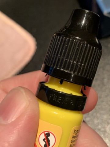 Opened e-liquid bottle with broken tamper-evident seal